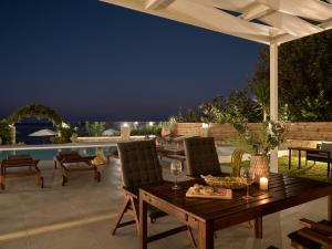 un patio con tavolo, sedie e piscina di Stefania Apartments a Kypseli
