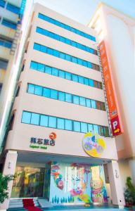 a tall white building with a sign on it at Legend Hotel Kaohsiung Liuhe in Kaohsiung