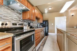 a kitchen with wooden cabinets and a stove top oven at Stunning Condos Near French Quarter in New Orleans