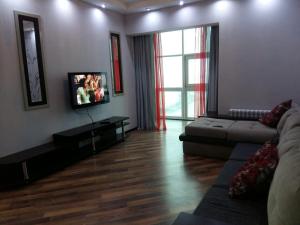 a living room with a couch and a flat screen tv at Апартаменты на набережной с панорамным видом на 39 этаже in Astana