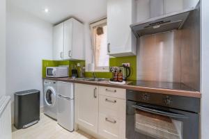 a kitchen with a sink and a stove top oven at Wonderful London mansion in the heart of Marylebone in London