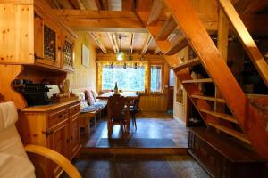 a kitchen and dining room with a spiral staircase in a cabin at ~Chalet_Rifugio tra i boschi~ in Sella Nevea