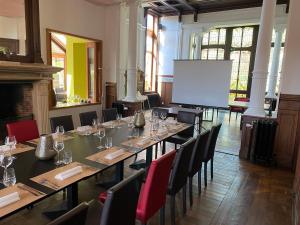 una sala de conferencias con una mesa larga, sillas y una pantalla en Maison Dispa, en Walcourt