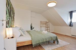 Stay&Dream - 75m² - Two Bedrooms - Kitchen - Netflix في إيسن: غرفة نوم بسرير وبطانية خضراء
