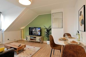 Stay&Dream - 75m² - Two Bedrooms - Kitchen - Netflix في إيسن: غرفة معيشة مع طاولة وتلفزيون