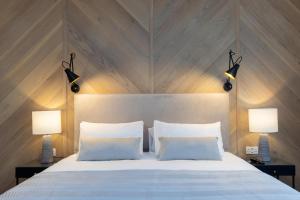 a bedroom with a large white bed with two lamps at The Kingswood in St Austell