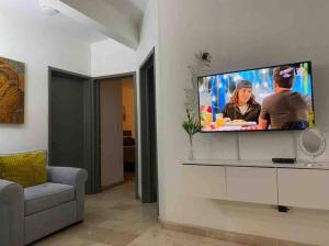 een woonkamer met een flatscreen-tv aan de muur bij Disfruta un agradable alojamiento en Rocky Point in Puerto Peñasco