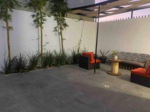 een patio met banken, een tafel en palmbomen bij Disfruta un agradable alojamiento en Rocky Point in Puerto Peñasco
