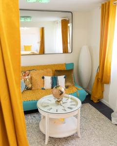 ein Wohnzimmer mit einem Sofa und einem Spiegel in der Unterkunft Suite-Airport-Basel in Blotzheim
