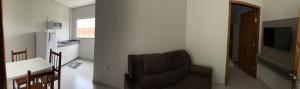 博尼圖的住宿－Confort Flats，客厅配有椅子、桌子和电视