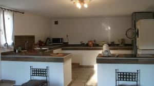 a kitchen with a counter and two chairs in it at T2 dans la région Bastiaise vue sur la mer in Furiani