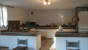 - une cuisine avec un comptoir et 2 chaises dans l'établissement T2 dans la région Bastiaise vue sur la mer, à Furiani
