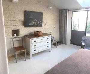 ein Schlafzimmer mit einer weißen Kommode und einem TV an der Wand in der Unterkunft Maison de Campagne in Beautiful Burgundy in Noyers-sur-Serein