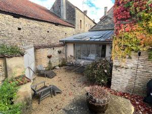 a courtyard of a house with benches and a window at Maison de Campagne in Beautiful Burgundy in Noyers-sur-Serein