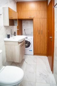 een badkamer met een toilet en een wasmachine bij Studio apartment with all amenities in Kolonaki in Athene