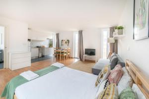 a bedroom with a bed and a living room at Ourique Charm Apartments in Lisbon