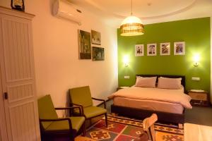 1 dormitorio con paredes verdes, 1 cama y sillas en Old Radio hostel, en Samarkand
