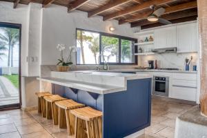 a kitchen with a large blue island with stools at Casa La Palapa in Esparza