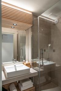 a bathroom with a white sink and a shower at La Cachette, Friendly Hotel & Spa in Arc 1600