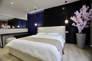 1 dormitorio con 1 cama grande y un jarrón con flores en La Grand - New Bazaar, en Tirana