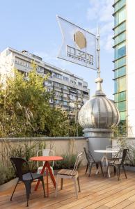 eine Terrasse mit Stühlen, einem Tisch und einem Schild in der Unterkunft Rosetti Hotel in Bukarest