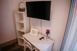 a small white table with a tv on a wall at Elephant's Smile B&B in Catania