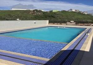 a large blue swimming pool on top of a building at Apartamento em Arraial do Cabo 501 in Arraial do Cabo