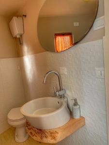 a bathroom with a sink and a toilet and a mirror at AL CORNIOLO in Zerba +39 photos