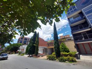 a street in a city with trees and a building at Apartamento Laureles la 33 in Medellín