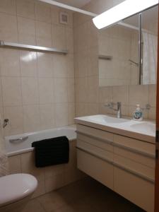 a bathroom with a sink and a tub and a toilet at Rose Davos in Davos +20 photos