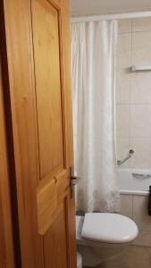 a bathroom with a toilet and a sink and a door at Rose Davos in Davos