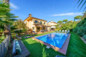 a backyard with a swimming pool and a house at VIlla Jaruco Lux, exclusiva zona residencial con Piscina & Aircon in Lloret de Mar