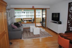 a living room with a couch and a tv at Rose Davos in Davos
