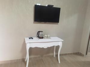 a white table with a tv on a wall at Dudsk Enyonini in Newcastle