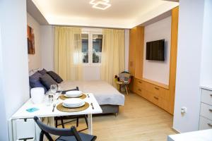 Habitación pequeña con cama, mesa y cocina en Studio apartment with all amenities in Kolonaki, en Atenas