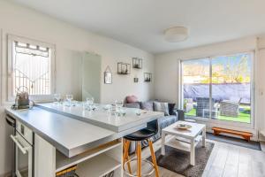 Charming duplex with big terrace- Cabourg - Welkeys في كابورغ: مطبخ وغرفة معيشة مع جزيرة بيضاء كبيرة