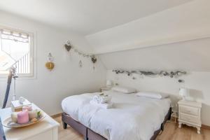 a white bedroom with a bed and a window at Charming duplex with big terrace- Cabourg - Welkeys in Cabourg