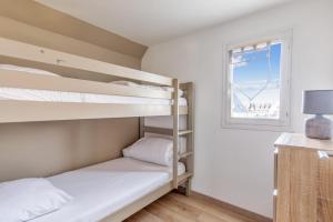 卡布爾的住宿－Charming duplex with big terrace- Cabourg - Welkeys，一间卧室设有两张双层床和一扇窗户。