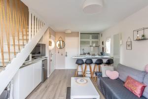 een woonkamer met een bank en een keuken bij Charming duplex with big terrace- Cabourg - Welkeys in Cabourg
