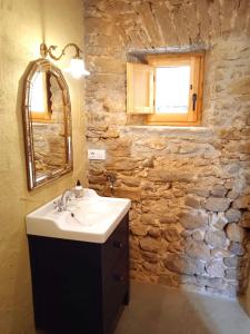 baño con lavabo y pared de piedra en L'espigol "antiga era", en Sant Jordi Desvalls