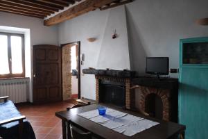Casa Vacanze Il Torchio في بيانكاستانايو: غرفة معيشة مع طاولة ومدفأة