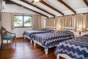 a room with three beds and a window at Casa La Palapa Main House in Tivives