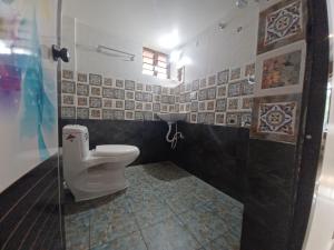 baño con aseo y puerta de cristal en JEENA MOTEL, en Kollam