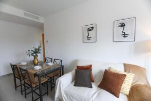 sala de estar con sofá blanco y mesa en RentalSevilla Apartamento luminoso 2 dormitorios, en Sevilla