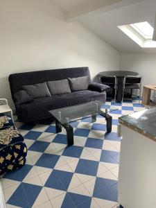 salon z kanapą i niebiesko-białą podłogą w obiekcie SUITS & LUXURY Appart Paris Montreuil w mieście Montreuil