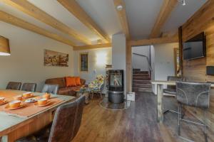 a living room with a fireplace and a table with chairs at Chalets AurAlpin in Kleinarl