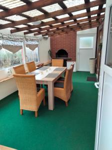 a dining room with a table and chairs on a green floor at Bungalow in Kritzmow