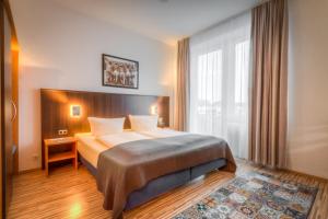 um quarto de hotel com uma cama e uma janela em Gästehaus Centro em Constança