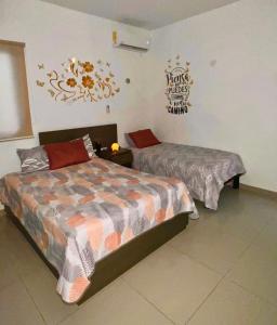 a bedroom with two beds and a sign on the wall at Departamento en Altabrisa Merida in Mérida +3 photos