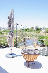 einen Stuhl und einen Tisch auf dem Balkon in der Unterkunft Red Bishop - Birds, Beach & Beauty in Langebaan